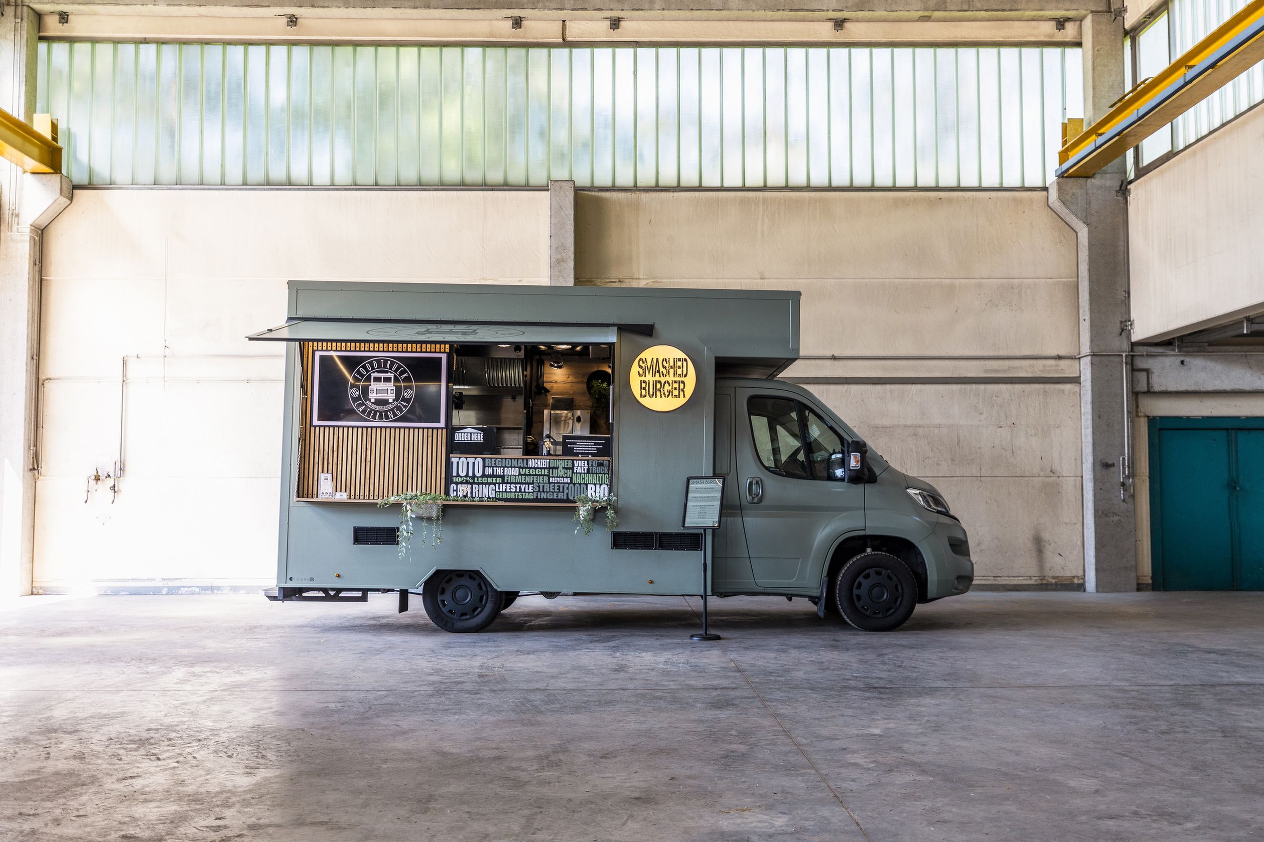Foodtruck von catering24 in einer großen halle.