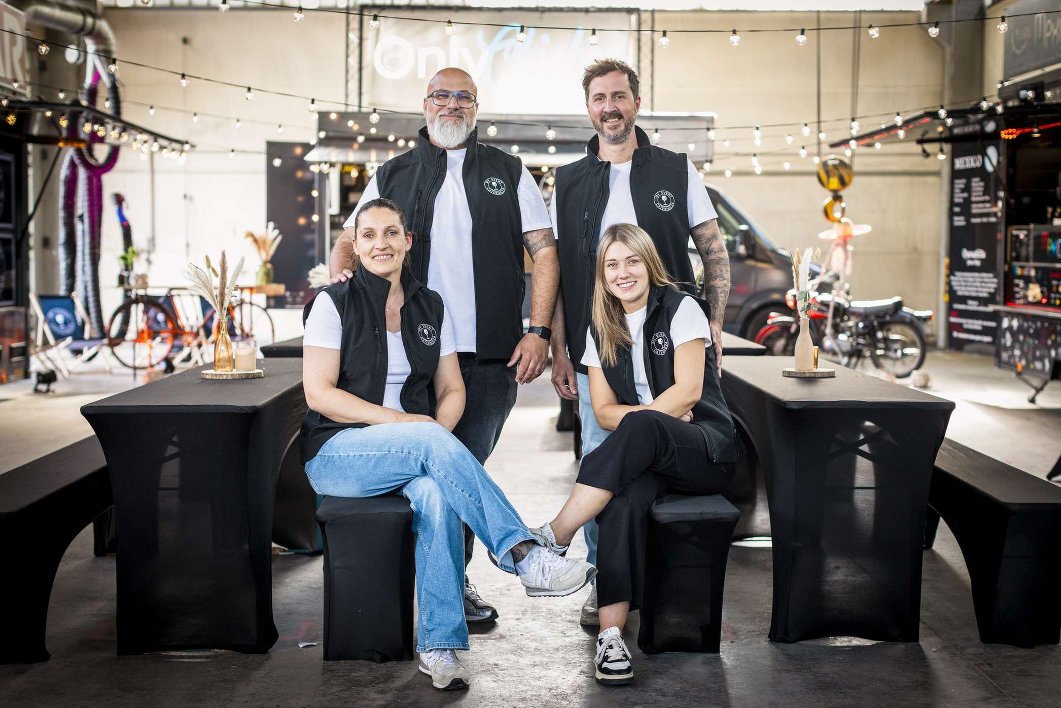 Ein Team des Unternehmens Foodtruck Catering24 sitzt an einem Tisch in einer modernen Umgebung.