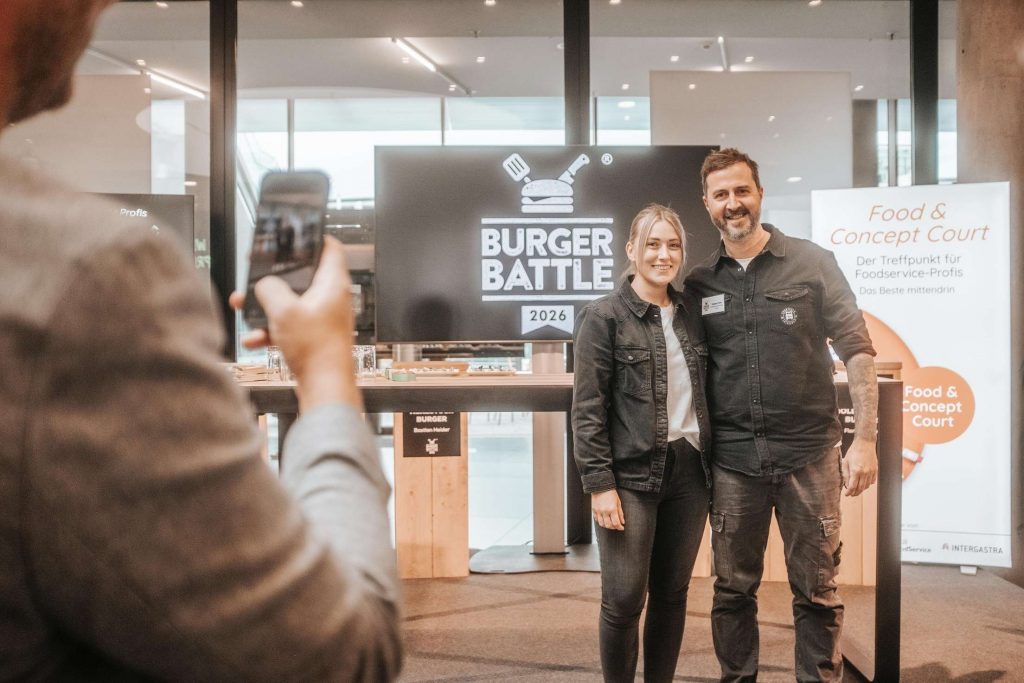 Personen posieren bei einer Burger-Battle-Veranstaltung fuer ein Foto