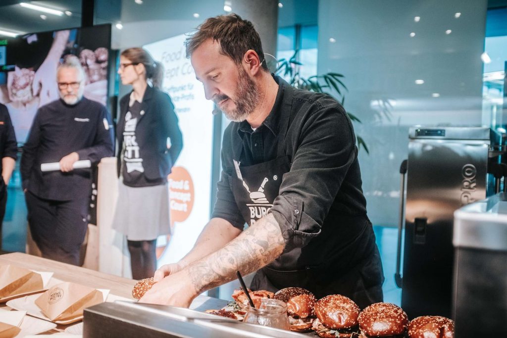 Ein Koch grillt Fleisch auf einem Event.