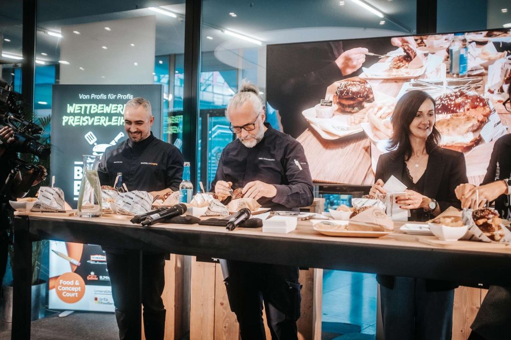 Menschen in einem Kochkurs bereiten zusammen Speisen zu.